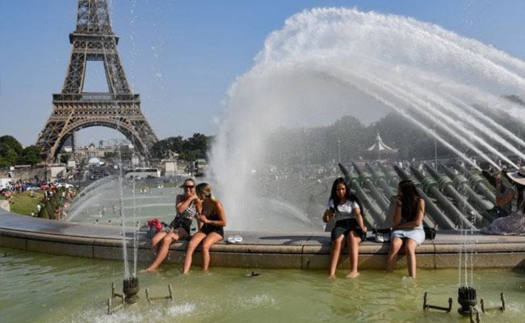 People cooling off in a fountain near the Eiffel Tower during a European heatwave